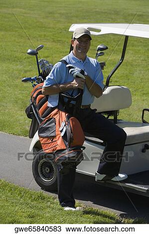 Stock Image - Portrait of a mature man carrying a golf bag. Fotosearch