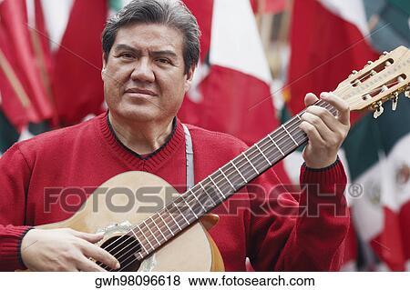 Portrait of a mature man playing an acoustic guitar View Large Photo Image Stock Photo - Portrait of a mature man playing an acoustic guitar. Fotosearch