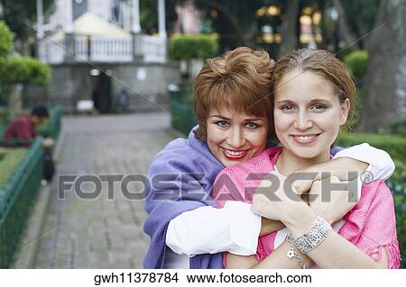 Portrait of a mature woman hugging her daughter from behind View Large Photo Image Picture - Portrait of a mature woman hugging her daughter from behind. Fotosearch
