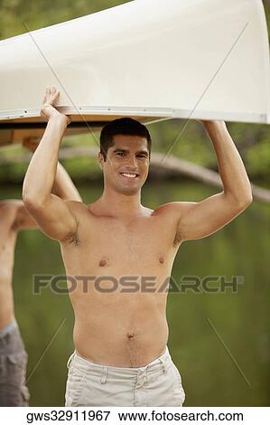 Portrait of a mid adult man carrying a boat over his head View Large Photo Image Stock Photo - Portrait of a mid adult man carrying a boat over his head. Fotosearch