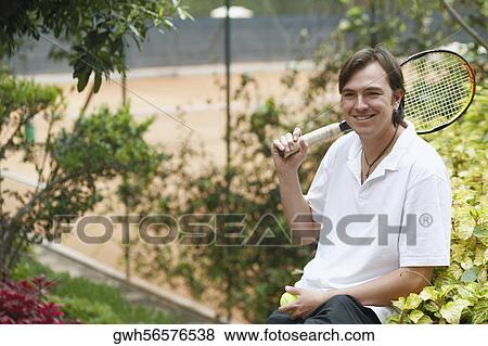 Portrait of a mid adult man holding a tennis ball and a tennis racket View Large Photo Image Stock Photo - Portrait of a mid adult man holding a tennis ball and a tennis racket. Fotosearch