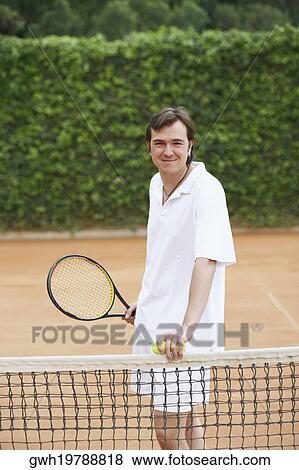 Portrait of a mid adult man holding two tennis balls and a tennis racket View Large Photo Image Stock Photo - Portrait of a mid adult man holding two tennis balls and a tennis racket. Fotosearch