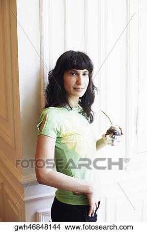 Picture - Portrait of a mid adult woman holding a glass. Fotosearch
