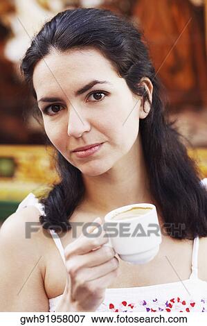 Portrait of a mid adult woman holding a cup of coffee View Large Photo Image Stock Photo - Portrait of a mid adult woman holding a cup of coffee. Fotosearch
