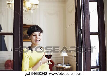 Portrait of a mid adult woman holding a glass of red wine and smiling View Large Photo Image Stock Photo - Portrait of a mid adult woman holding a glass of red wine and smiling. Fotosearch