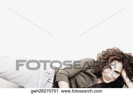 Stock Image - Portrait of a mid adult woman lying on the floor. Fotosearch