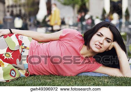 Portrait of a mid adult woman lying on the lawn View Large Photo Image Stock Image - Portrait of a mid adult woman lying on the lawn . Fotosearch