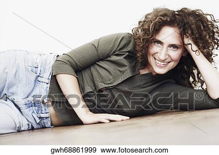 Stock Photo - Portrait of a mid adult woman lying on the floor. Fotosearch
