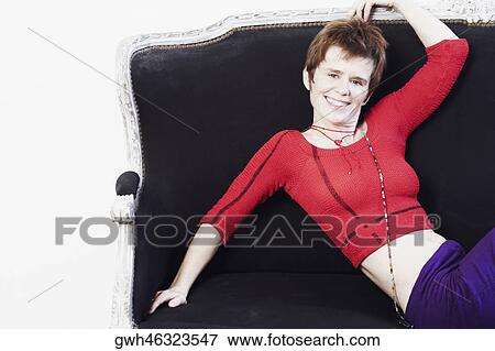 Stock Photo - Portrait of a mid adult woman reclining on a couch. Fotosearch