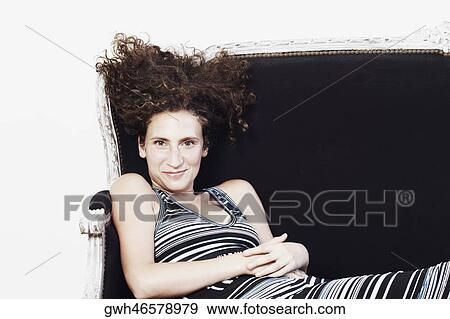 Portrait of a mid adult woman reclining on a couch View Large Photo Image Stock Photo - Portrait of a mid adult woman reclining on a couch. Fotosearch