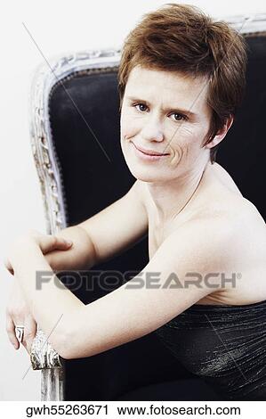 Portrait of a mid adult woman sitting on a couch View Large Photo Image Stock Image - Portrait of a mid adult woman sitting on a couch. Fotosearch