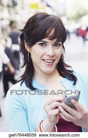 Portrait of a mid adult woman using a personal data assistant View Large Photo Image Stock Photo - Portrait of a mid adult woman using a personal data assistant . Fotosearch