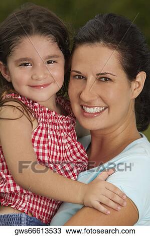 Stock Image - Portrait of a mother carrying her daughter. Fotosearch