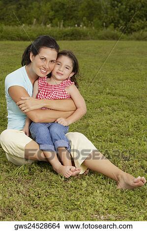 Picture - Portrait of a mother hugging her daughter from behind. Fotosearch