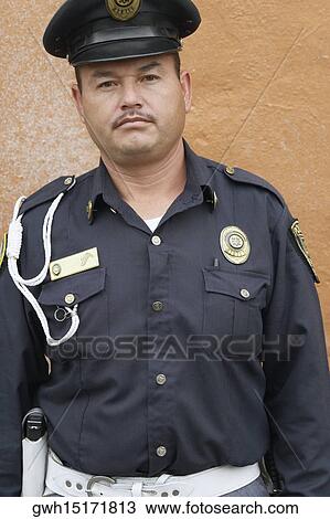 Portrait of a police officer standing in front of a wall View Large Photo Image Stock Image - Portrait of a police officer standing in front of a wall. Fotosearch