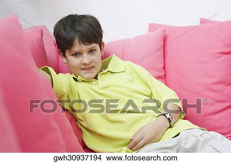 Portrait of a teenage boy sitting on a couch View Large Photo Image Picture - Portrait of a teenage boy sitting on a couch. Fotosearch