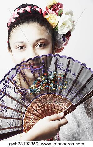 Portrait of a teenage girl covering her face with a folding fan View Large Photo Image Stock Photo - Portrait of a teenage girl covering her face with a folding fan. Fotosearch