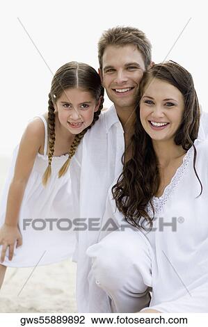 Stock Image - Portrait of a young couple and their daughter smiling. Fotosearch
