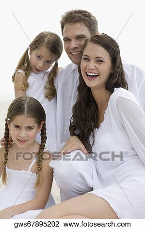 Stock Image - Portrait of a young couple and their two daughters smiling. Fotosearch