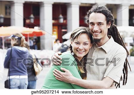 Picture - Portrait of a young couple embracing each other and smiling . Fotosearch