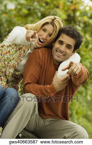 Portrait of a young couple pointing forward View Large Photo Image Stock Photo - Portrait of a young couple pointing forward. Fotosearch