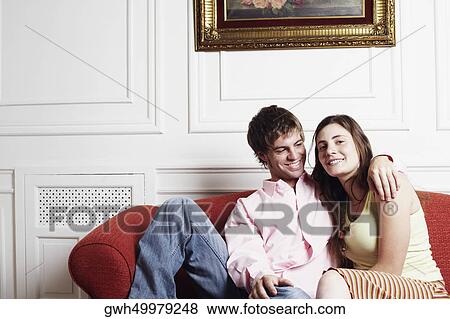 Portrait of a young couple sitting on a couch View Large Photo Image Stock Photo - Portrait of a young couple sitting on a couch. Fotosearch