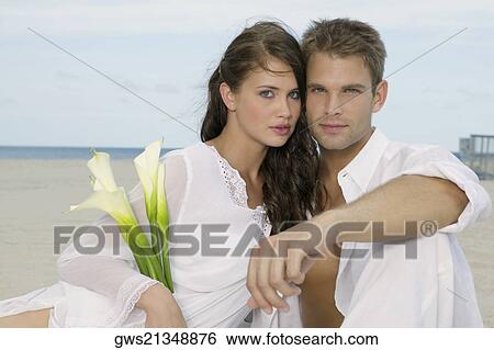 Portrait of a young couple sitting on the beach View Large Photo Image Stock Photograph - Portrait of a young couple sitting on the beach. Fotosearch