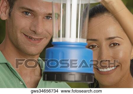 Picture - Portrait of a young couple with a lantern in front of them. Fotosearch
