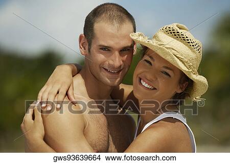 Picture - Portrait of a young man and a teenage girl embracing each other. Fotosearch