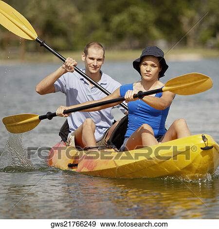Stock Photo - Portrait of a young man and a teenage girl kayaking. Fotosearch