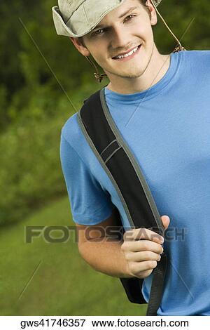 Stock Photo - Portrait of a young man carrying a backpack. Fotosearch