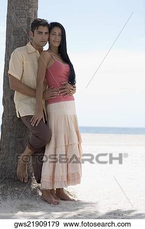 Portrait of a young man embracing a young woman on the beach View Large Photo Image Stock Photo - Portrait of a young man embracing a young woman on the beach. Fotosearch