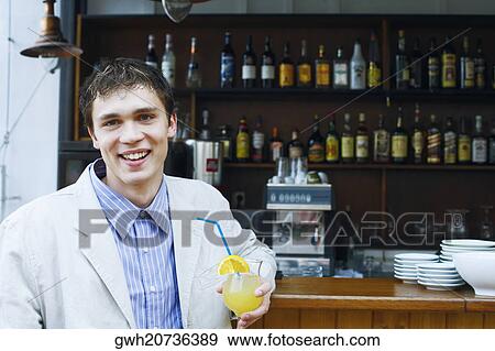 Portrait of a young man holding a drink View Large Photo Image Stock Photo - Portrait of a young man holding a drink . Fotosearch