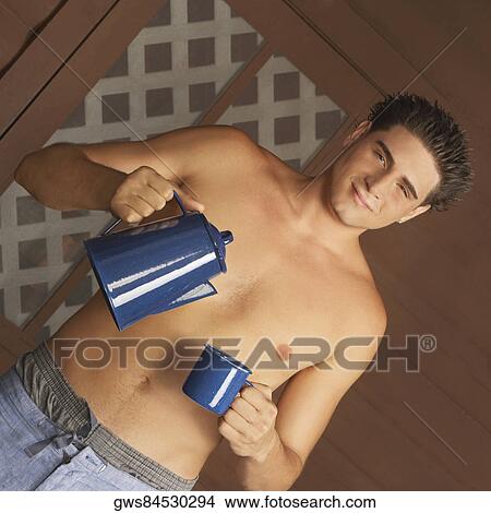 Portrait of a young man holding a tea cup and a tea kettle View Large Photo Image Picture - Portrait of a young man holding a tea cup and a tea kettle. Fotosearch