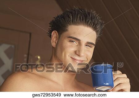 Portrait of a young man holding a tea cup and smiling View Large Photo Image Stock Photo - Portrait of a young man holding a tea cup and smiling. Fotosearch