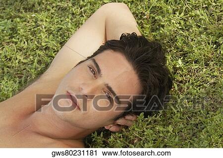 Portrait of a young man lying on the grass View Large Photo Image Stock Image - Portrait of a young man lying on the grass. Fotosearch