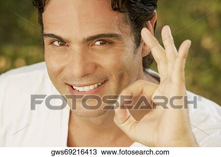 Portrait of a young man making an ok sign View Large Photo Image Stock Image - Portrait of a young man making an ok sign. Fotosearch