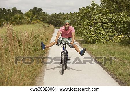 Portrait of a young man performing tricks on a bicycle View Large Photo Image Stock Image - Portrait of a young man performing tricks on a bicycle. Fotosearch