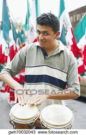 Portrait of a young man playing the bongo View Large Photo Image Stock Image - Portrait of a young man playing the bongo. Fotosearch