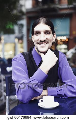 Picture - Portrait of a young man sitting with a cup of coffee . Fotosearch