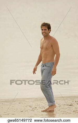Portrait of a young man standing on the beach and smiling View Large Photo Image Stock Image - Portrait of a young man standing on the beach and smiling. Fotosearch