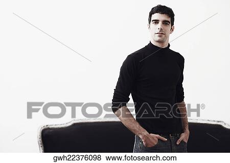 Portrait of a young man standing with his hands in his pockets View Large Photo Image Stock Photo - Portrait of a young man standing with his hands in his pockets. Fotosearch