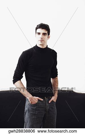Portrait of a young man standing with his hands in his pockets View Large Photo Image Stock Photograph - Portrait of a young man standing with his hands in his pockets. Fotosearch