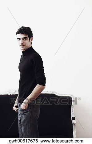 Portrait of a young man standing with his hands in his pockets View Large Photo Image Stock Photography - Portrait of a young man standing with his hands in his pockets. Fotosearch