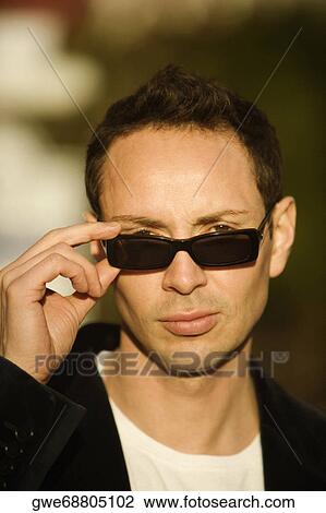 Stock Image - Portrait of a young man wearing sunglasses. Fotosearch