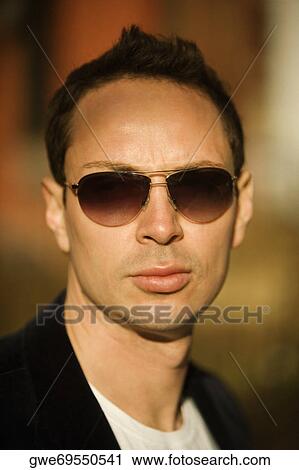 Portrait of a young man wearing sunglasses View Large Photo Image Stock Image - Portrait of a young man wearing sunglasses. Fotosearch
