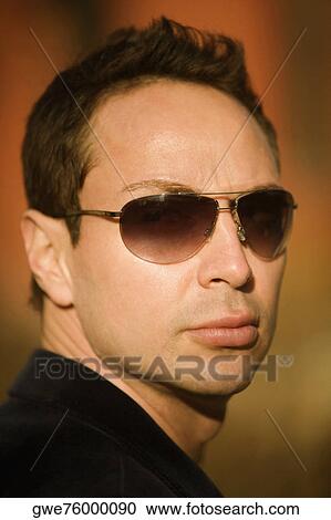 Stock Image - Portrait of a young man wearing sunglasses. Fotosearch