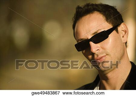 Portrait of a young man wearing sunglasses View Large Photo Image Stock Photo - Portrait of a young man wearing sunglasses. Fotosearch