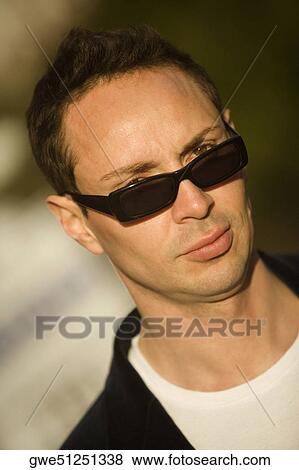 Stock Photo - Portrait of a young man wearing sunglasses. Fotosearch