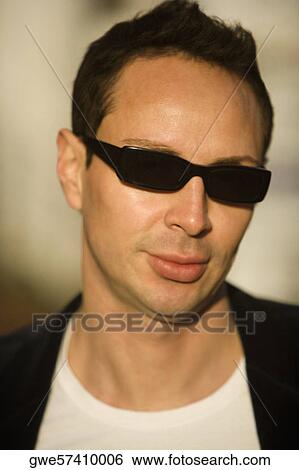 Stock Photograph - Portrait of a young man wearing sunglasses. Fotosearch